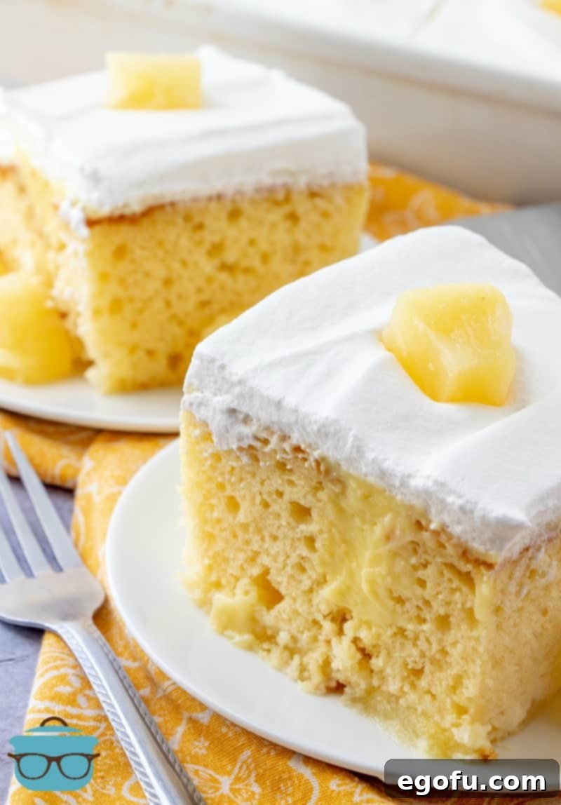 Multiple slices of Pineapple Pudding Poke Cake, each showcasing the layers of cake, pudding, and whipped topping with pineapple chunks.