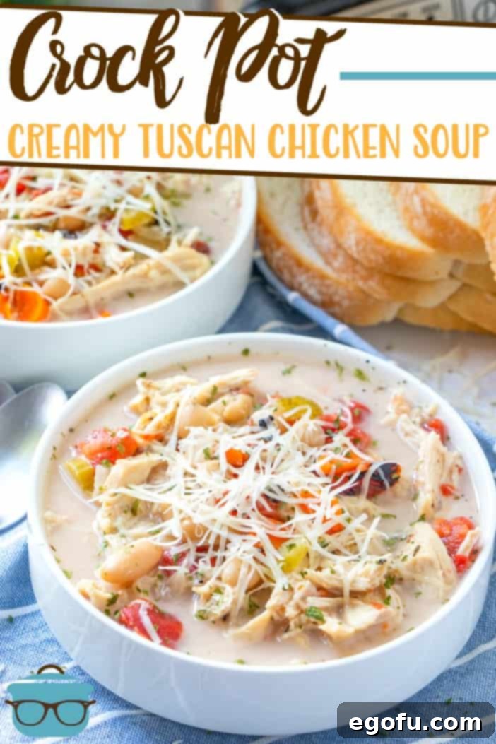 Crock Pot Creamy Tuscan Chicken Soup recipe from The Country Cook, pictured served into two white bowls with Italian sliced bread in the background.