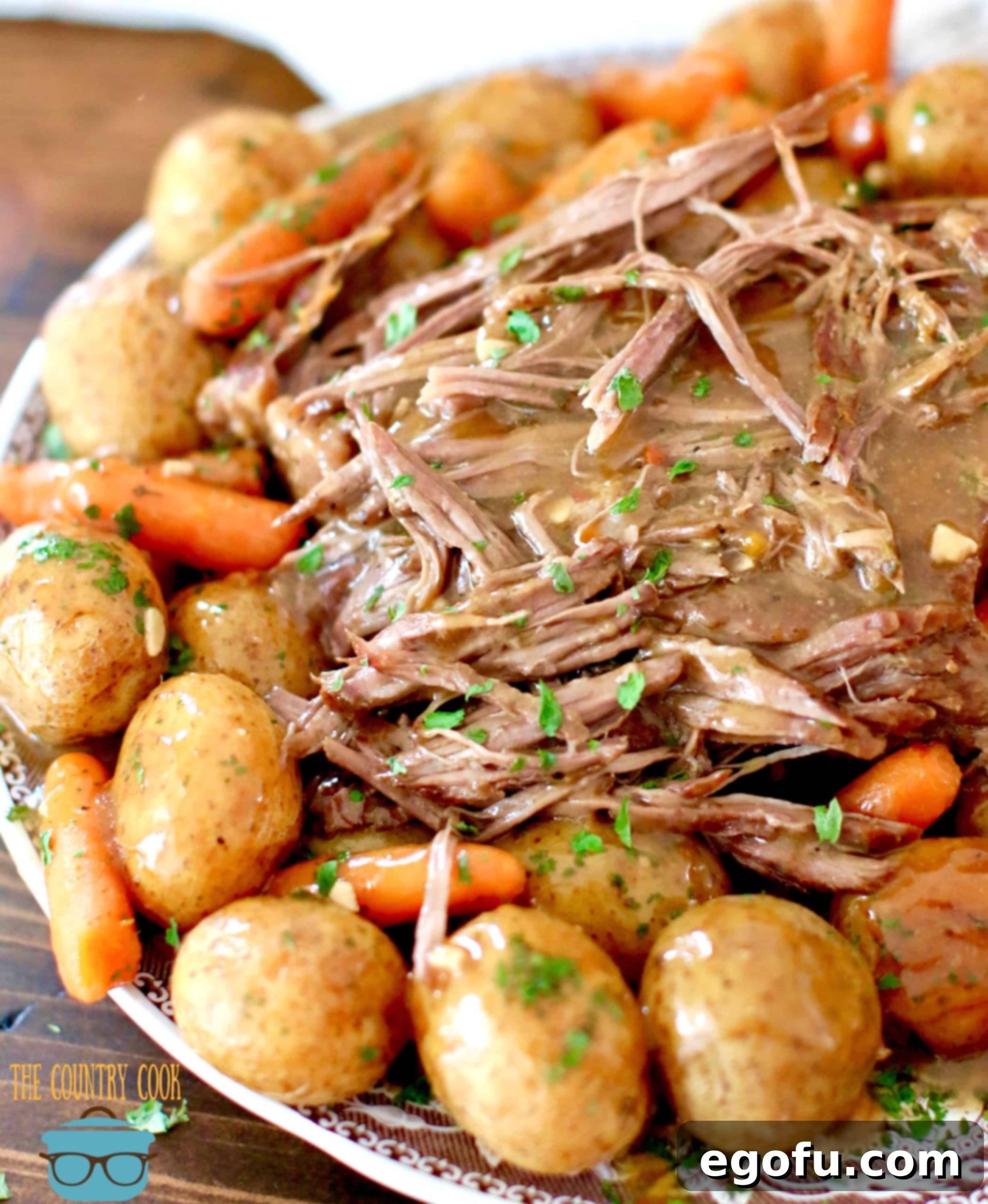 Perfect Instant Pot Roast with gravy shown on a brown and white plate.