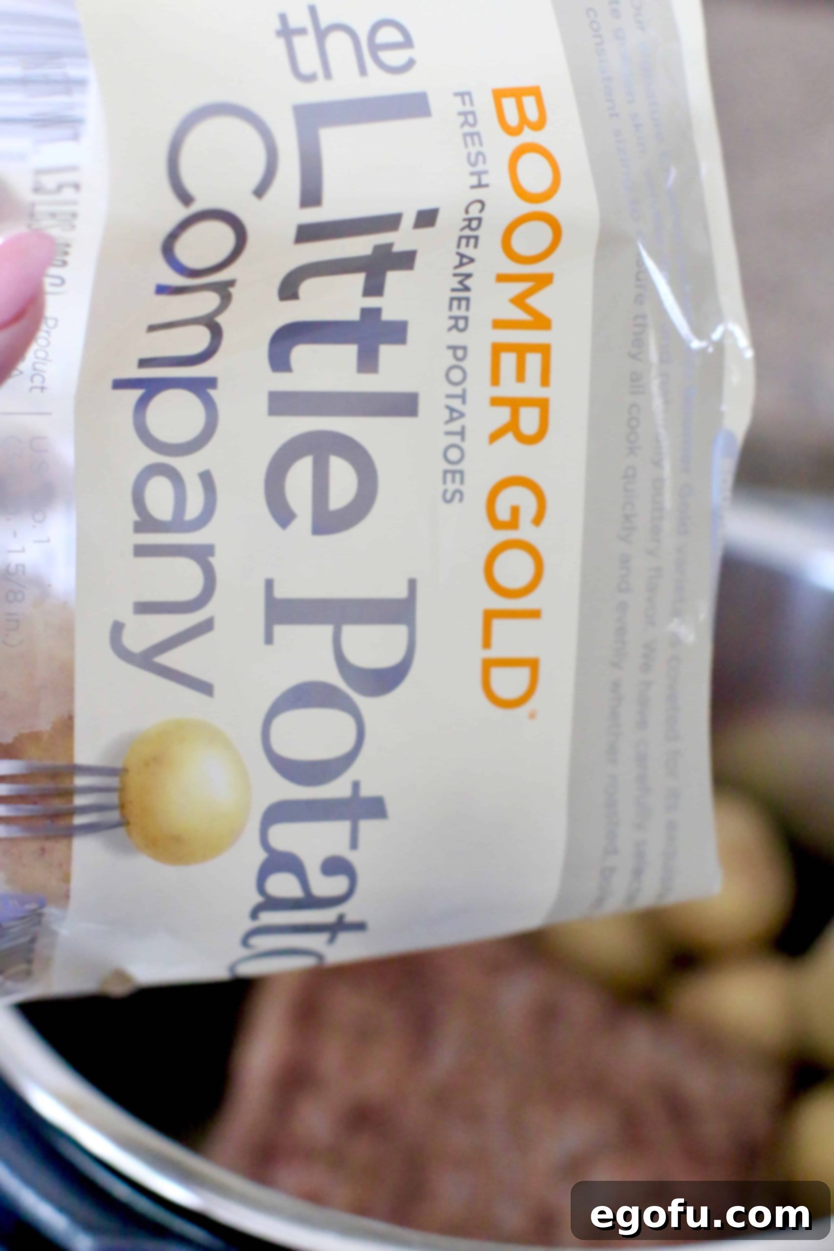 adding baby potatoes to pot roast into electric pressure cooker.