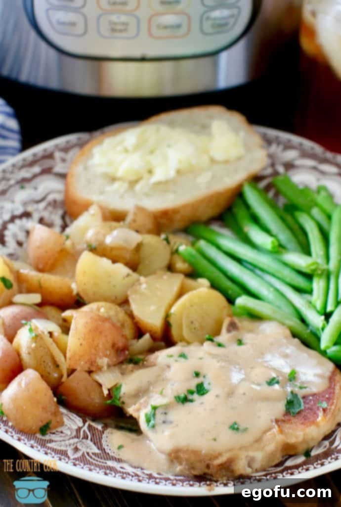 Instant Pot Pork Chops and Gravy and Potatoes shown on a plate with steamed green beans.