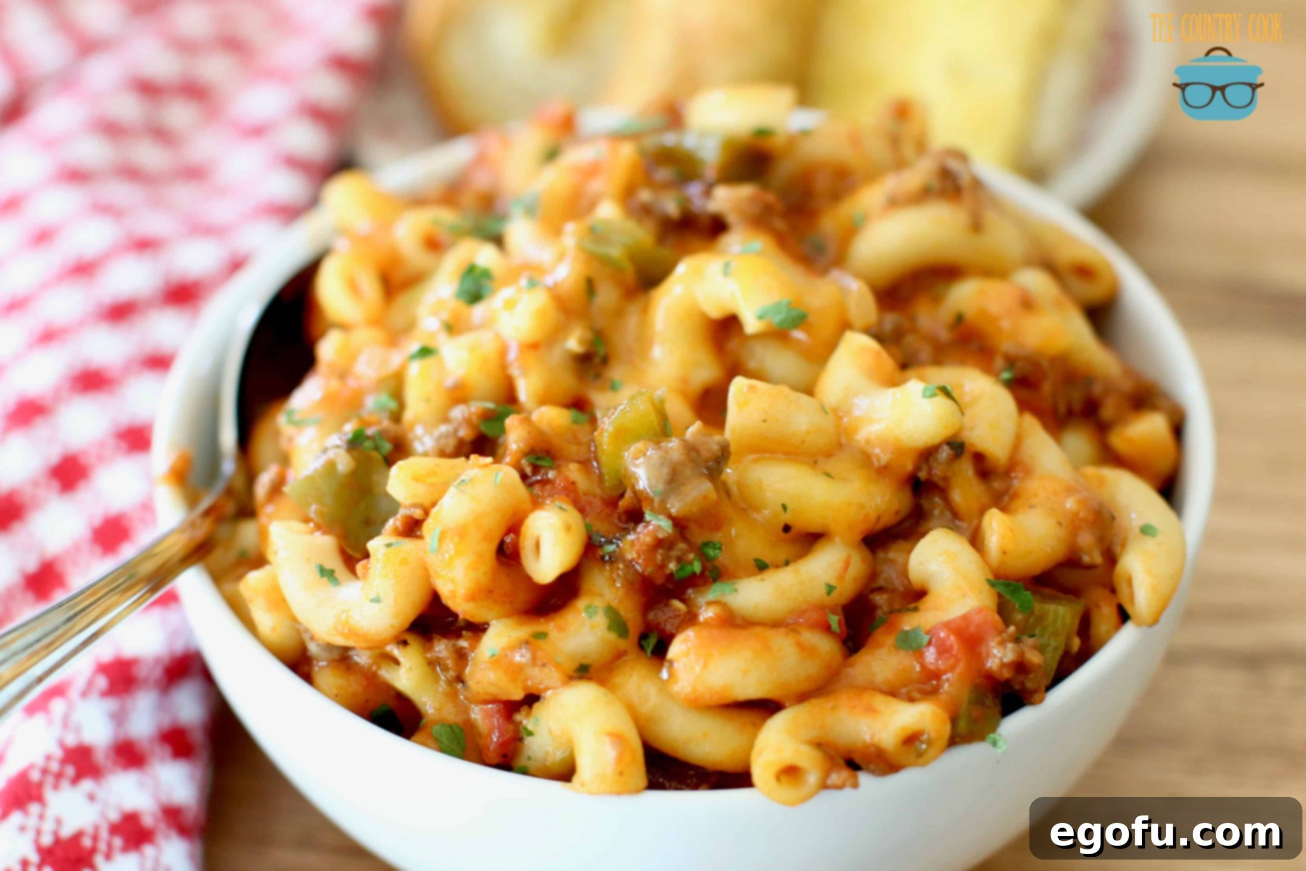 Hearty Instant Pot American Goulash 2 Instant Pot American Goulash with ground beef in a serving bowl, garnished with fresh parsley and served with a side of garlic bread, showcasing its rich texture and cheesy topping.