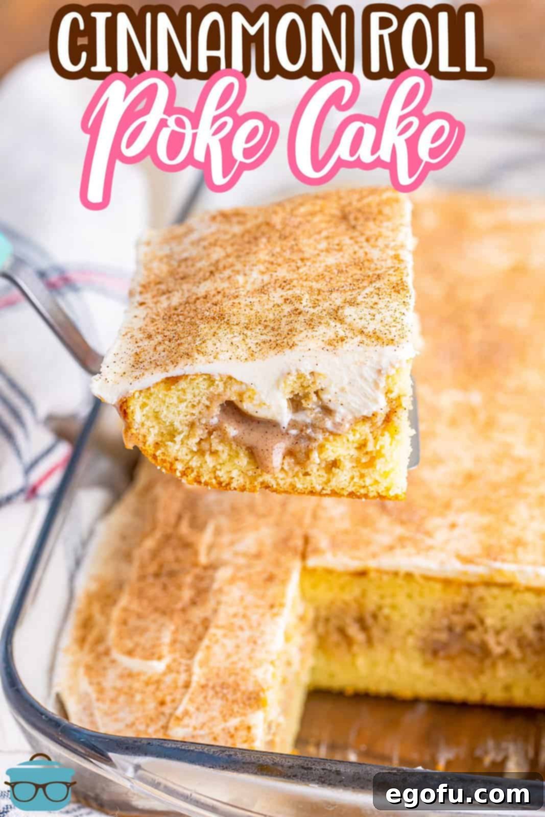 Cinnamon Swirl Poke Cake 9 A tantalizing view of a spatula lifting a slice of Cinnamon Roll Poke Cake, revealing the moist layers and rich filling within the baking dish.