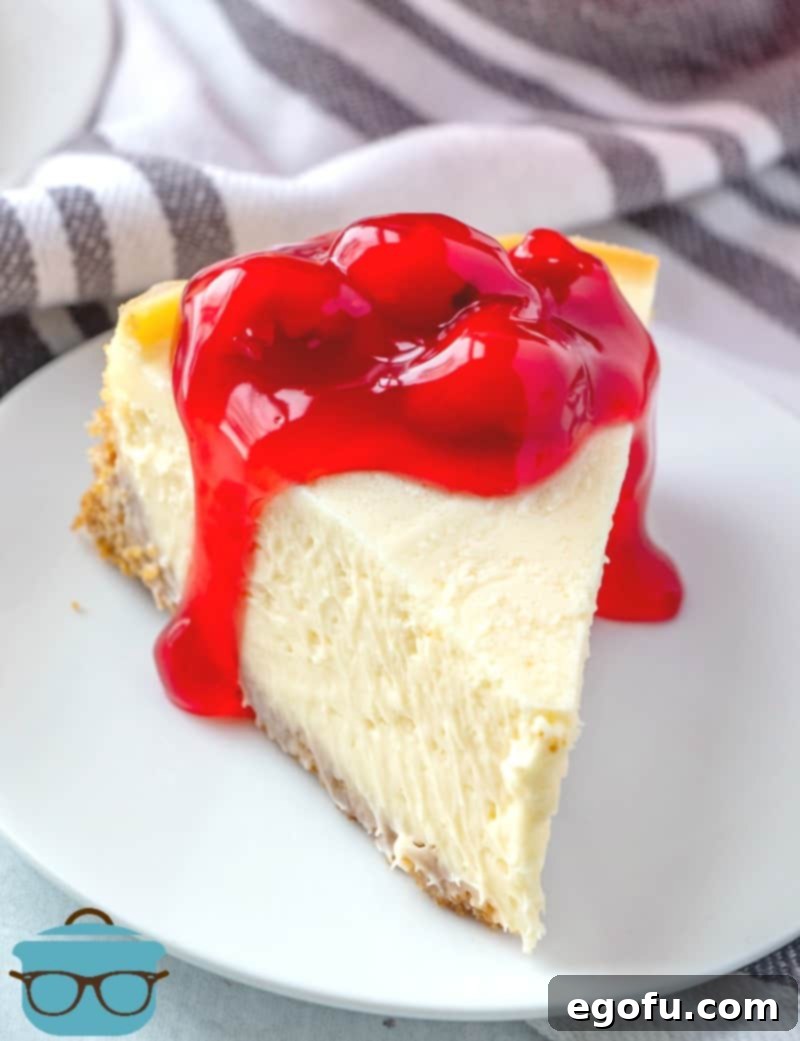 The Ultimate Instant Pot Cheesecake 2 Instant Pot Cheesecake, slice on a white plate topped with cherry pie filling.