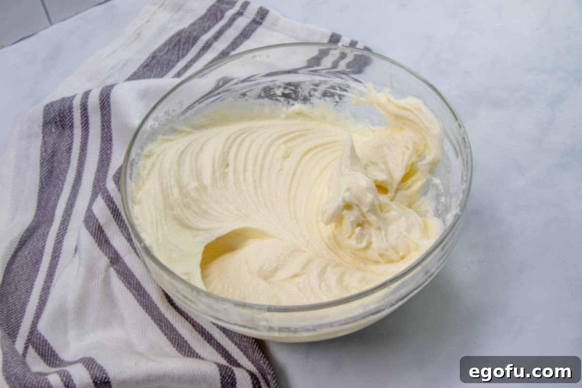 The Ultimate Instant Pot Cheesecake 7 softened cream cheese and sugar mixed together with an electric mixer in a bowl.