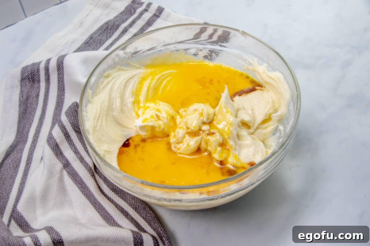 The Ultimate Instant Pot Cheesecake 8 sour cream, melted butter and beaten eggs added to cream cheese mixture in a large bowl.