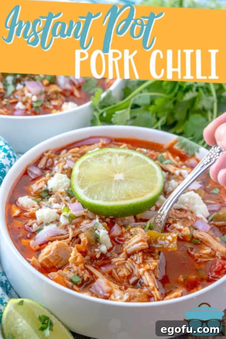 Instant Pot Pork Chili recipe from The Country Cook presented in a white bowl, garnished with a fresh slice of lime and cilantro.