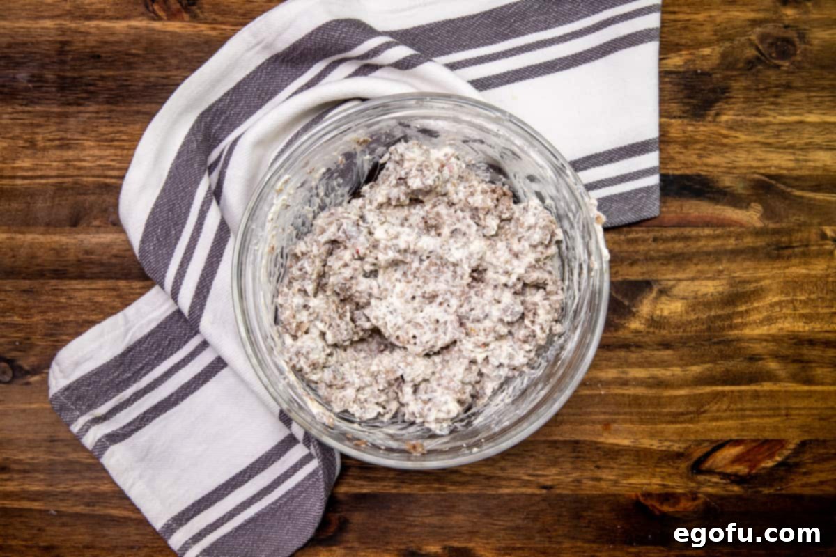 Sausage Rolls with Flaky Pastry 6 Cooked pork sausage mixed together with softened cream cheese in a bowl, ready for filling.