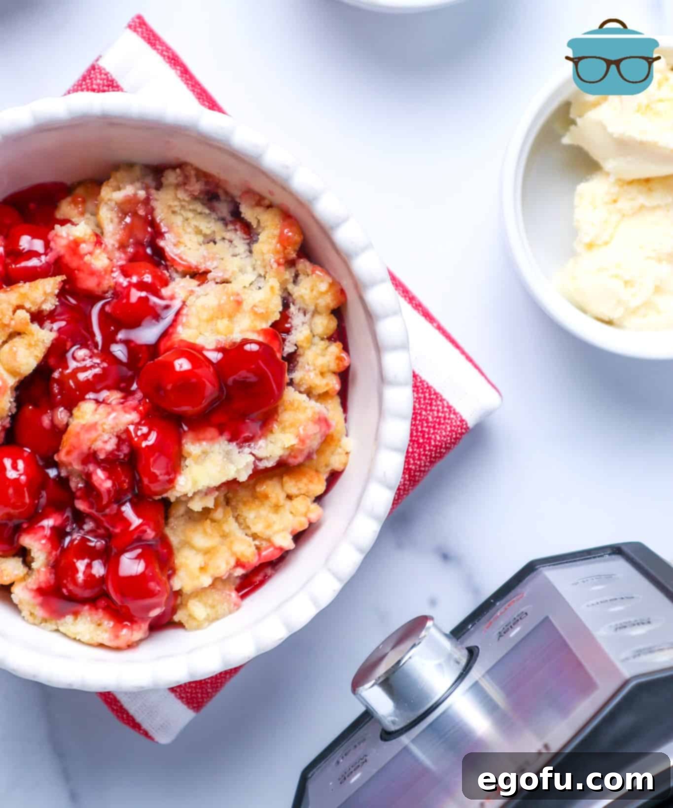 Instant Pot Cherry Cobbler shown served in a bowl with a side of vanilla ice cream.