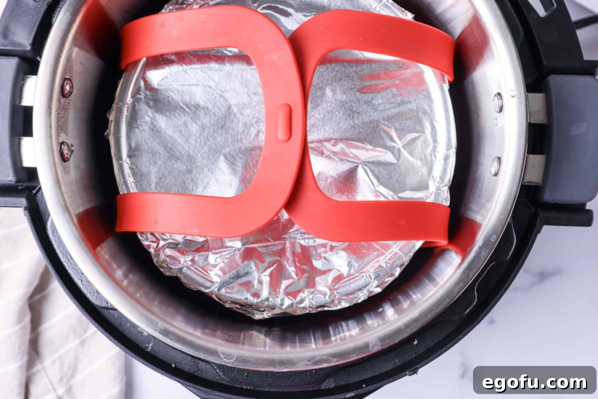 cherry cobbler pan inside an electric pressure cooker on a red rubber sling.
