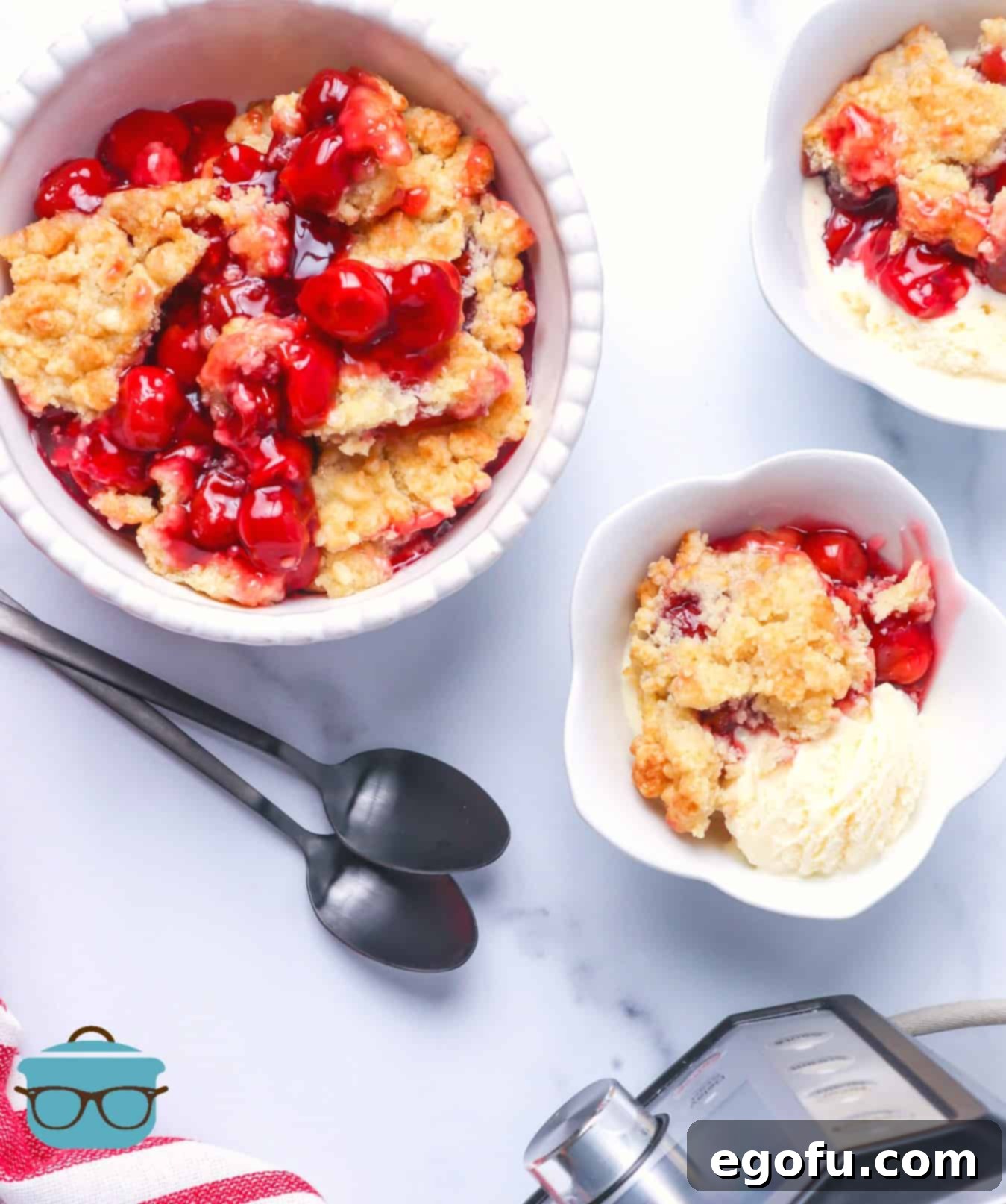 Electric Pressure cooker cherry cobbler served in white bowls with silver spoons.