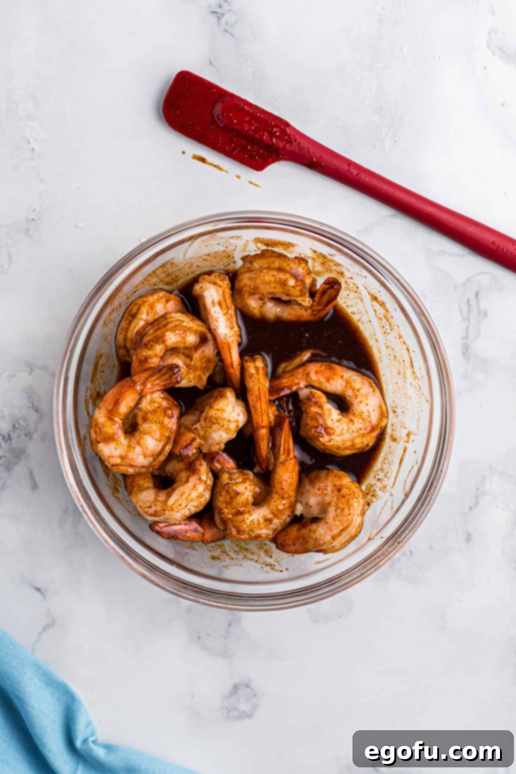 cooked shrimp in a bowl mixed together with barbecue sauce, soy sauce and Worcestershire sauce.
