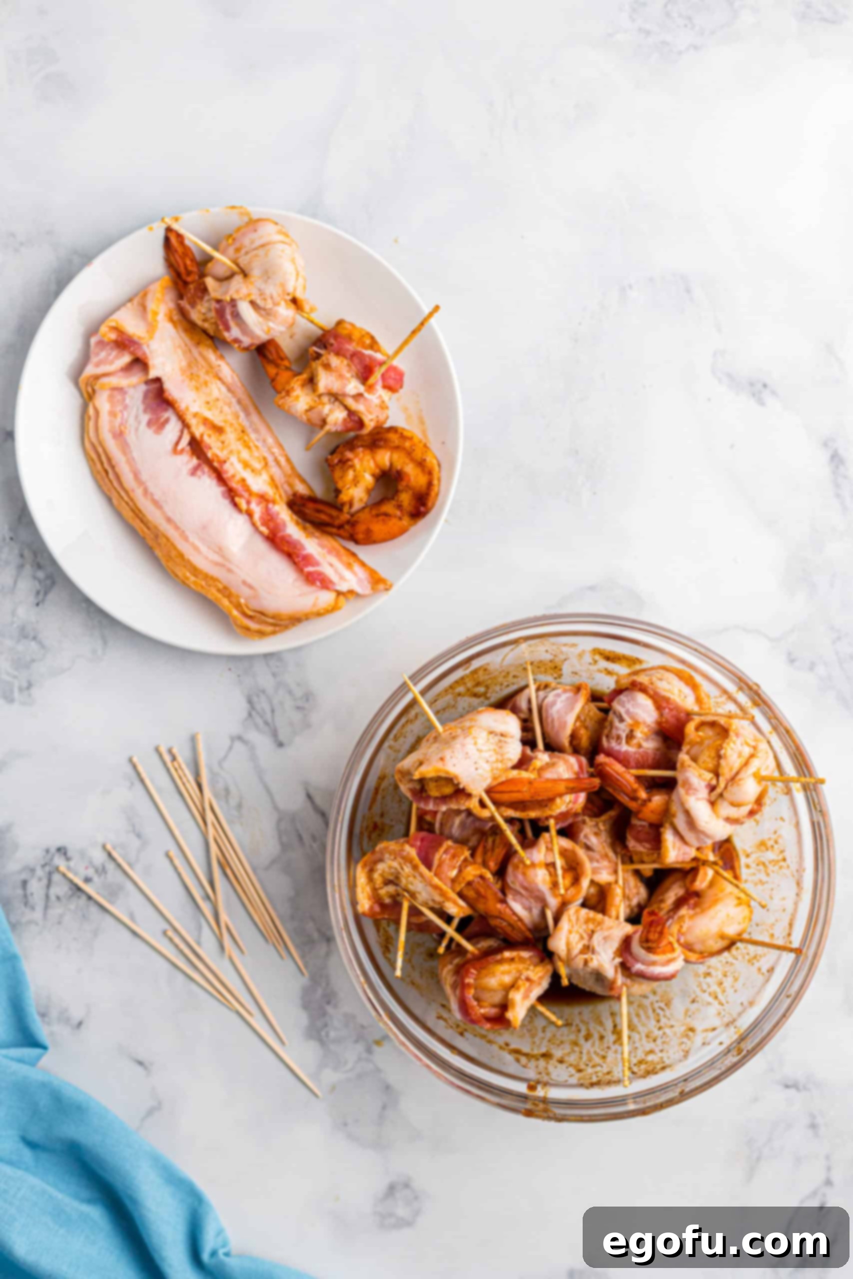 wrapping seasoned shrimp with slices of bacon and skewered with toothpicks.