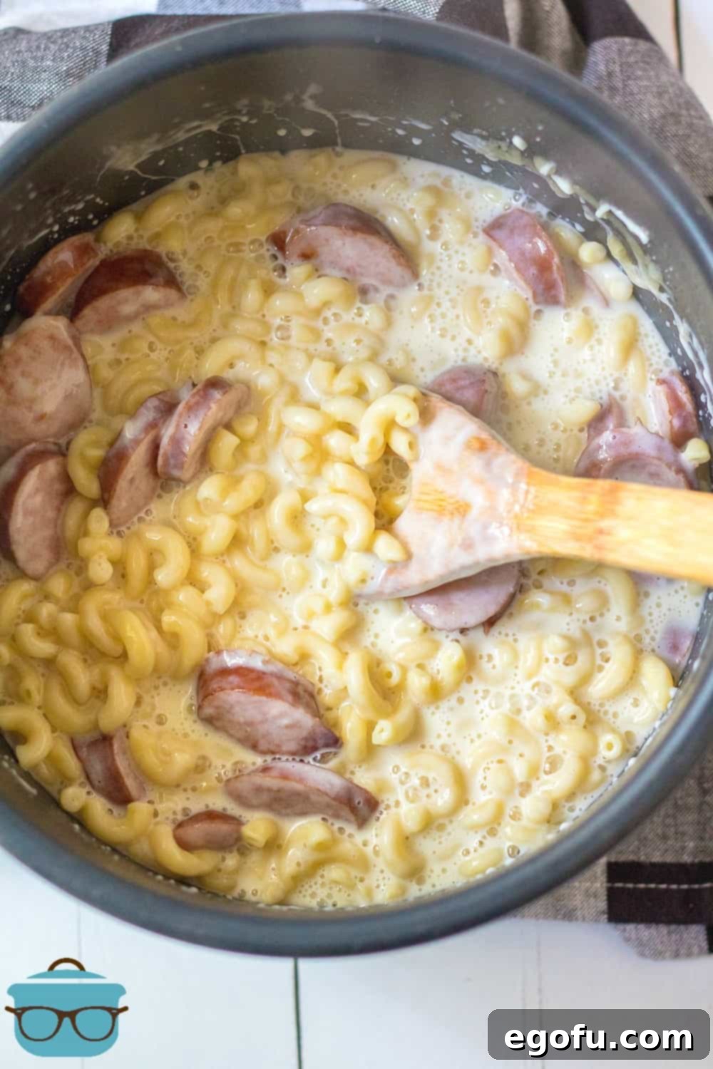 Creamy Instant Pot Sausage Mac and Cheese 9 A close-up of macaroni and cheese with sausage being stirred in the Instant Pot until the cheese is fully melted and incorporated, creating a creamy sauce.