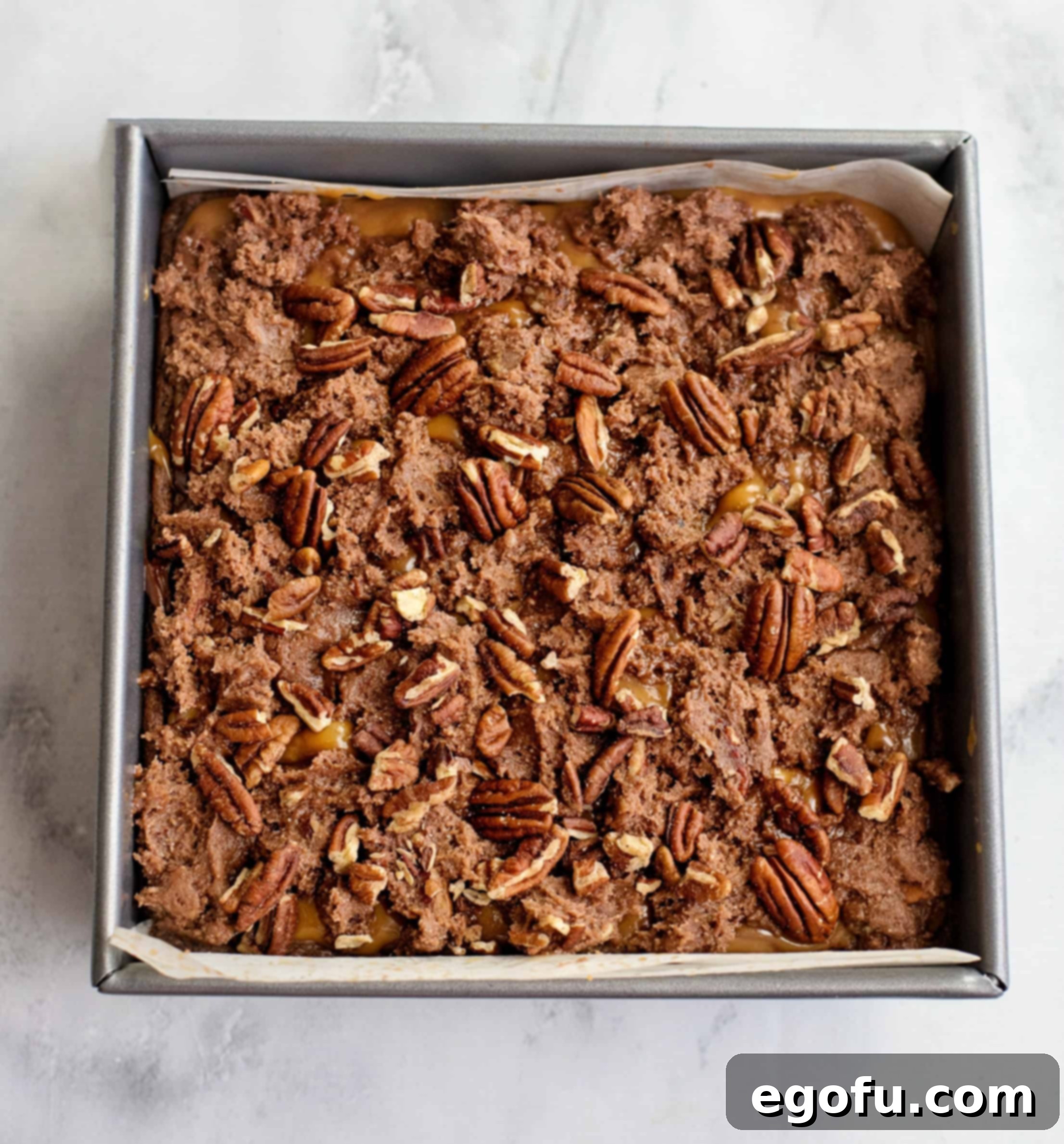 Chopped pecans sprinkled generously on top of the caramel and crumbled brownie mixture before final baking.