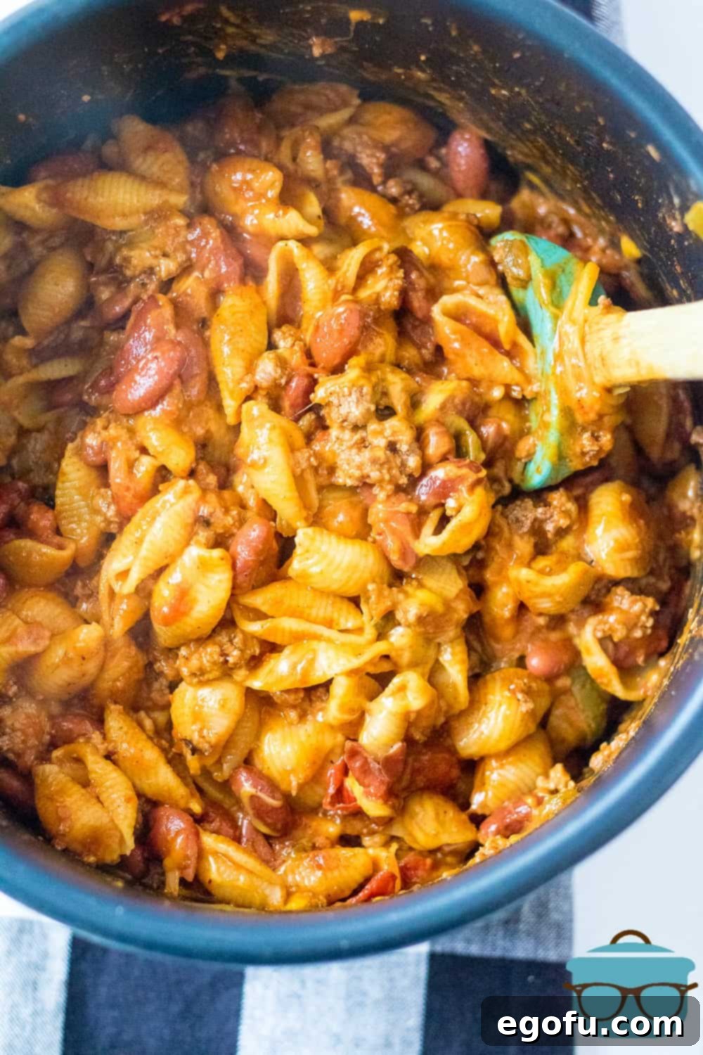 fully cooked, Cheesy Taco Pasta shown in the Instant Pot insert and a spatula.