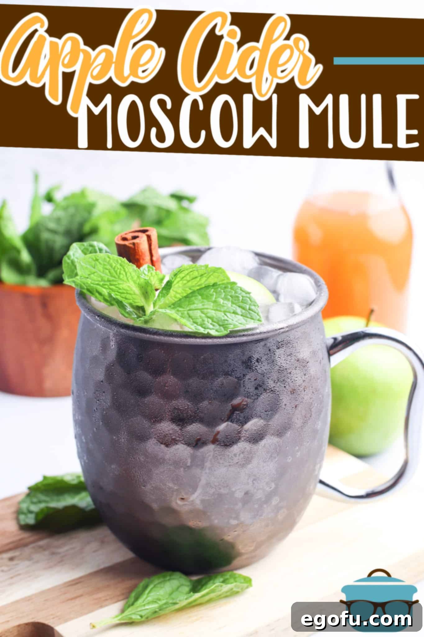 Apple Cider Moscow Mule with apple cider and Fireball recipe from The Country Cook, shown in a silver cup topped with a cinnamon stick.