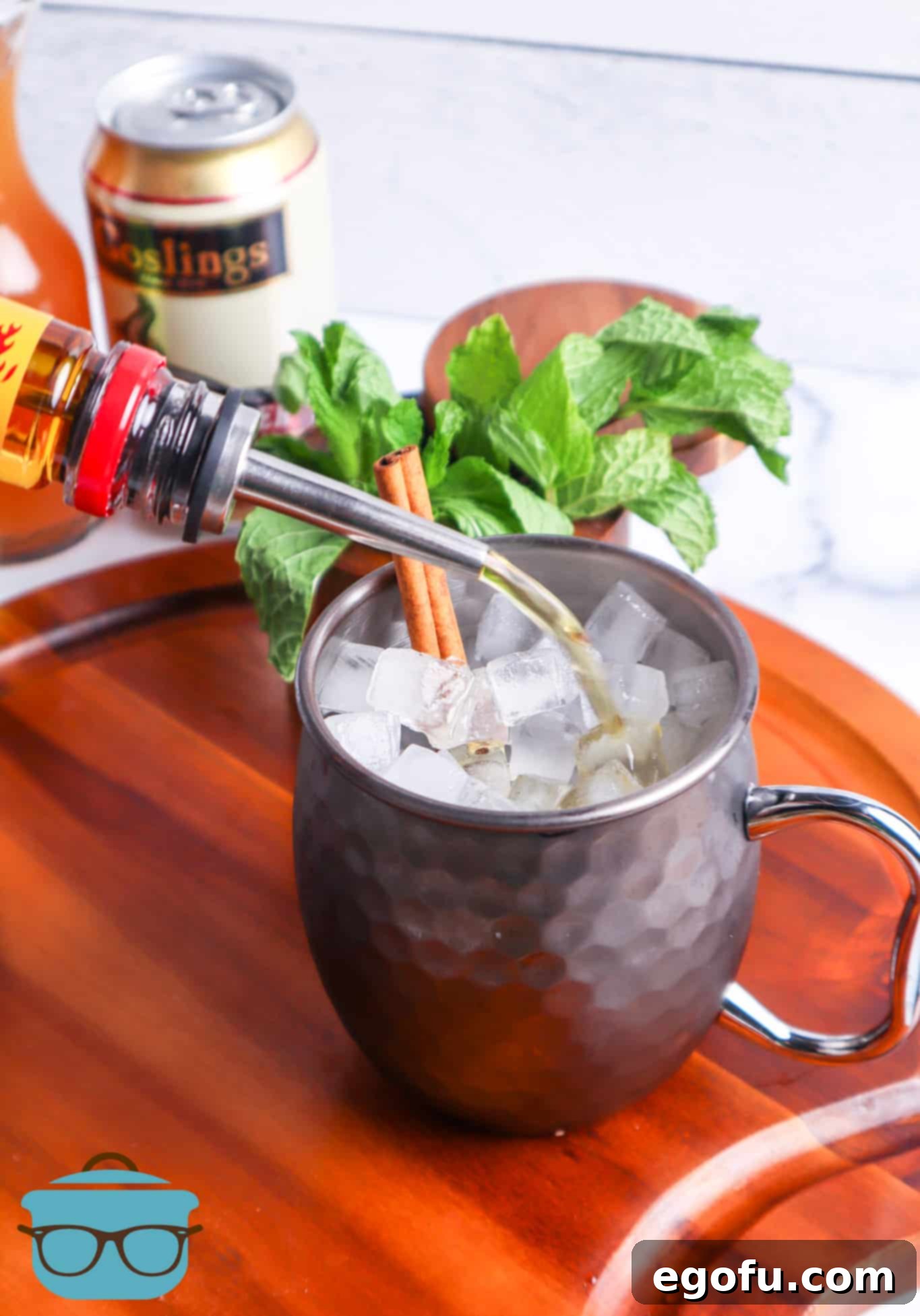 Fireball alcohol being poured into a Moscow Mule Mug.