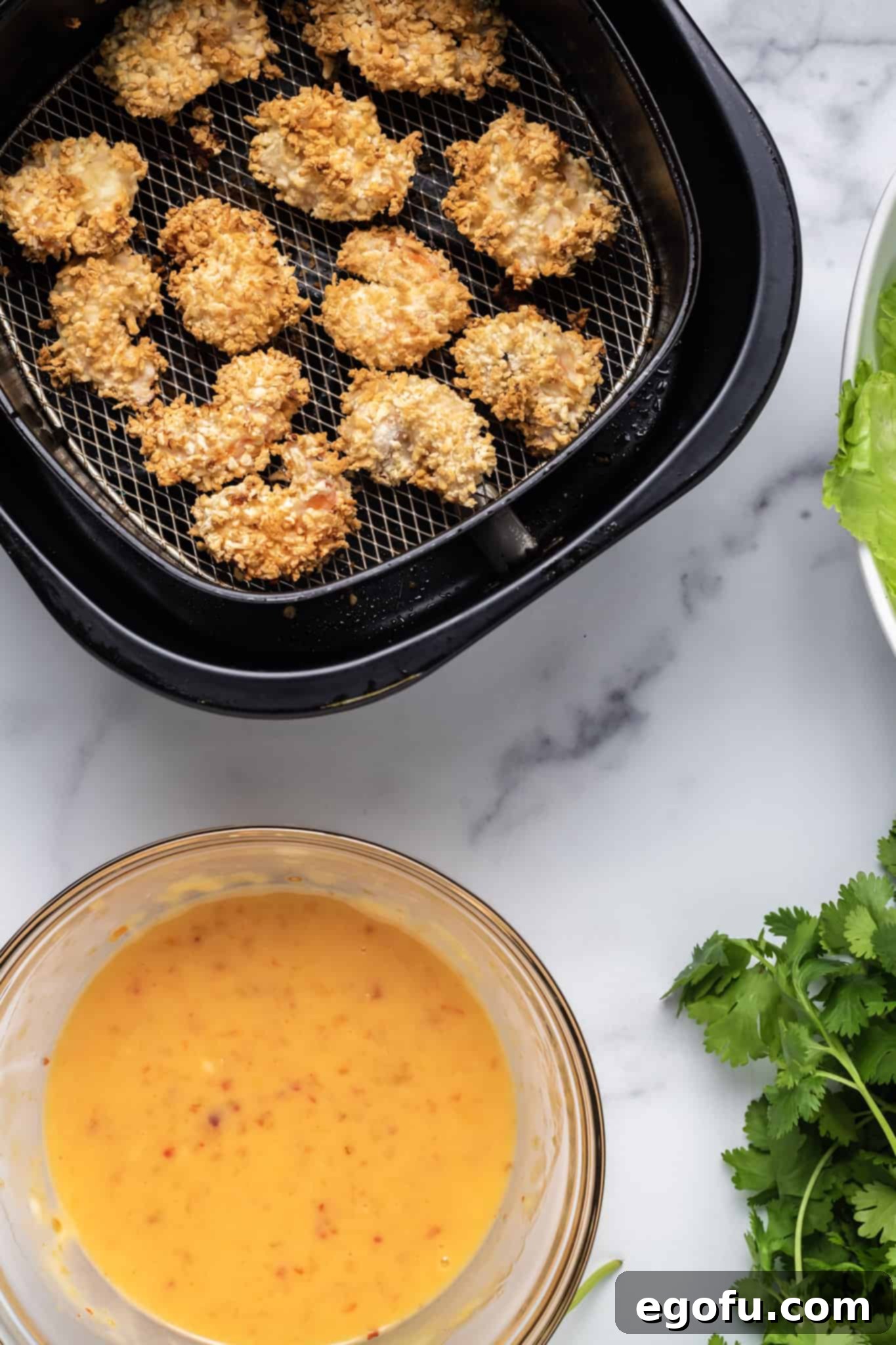 Golden brown, perfectly air-fried Panko-coated shrimp glistening in an air fryer basket, showcasing their crispy texture.