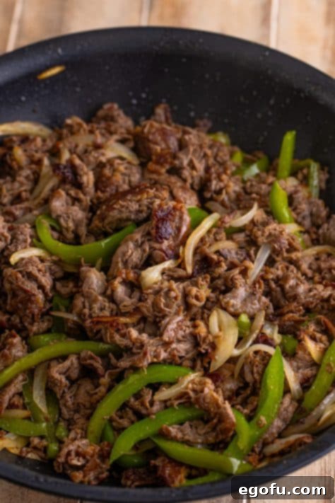Cooked steak and veggies back in a skillet.