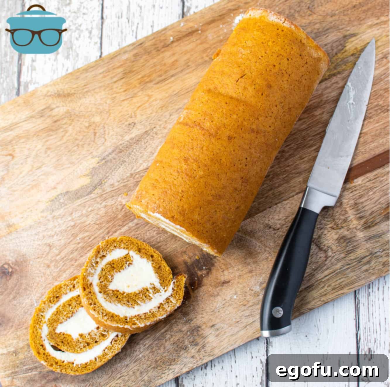 Perfectly cut 1-inch slices of homemade pumpkin roll arranged on a wooden cutting board, ready to be served.
