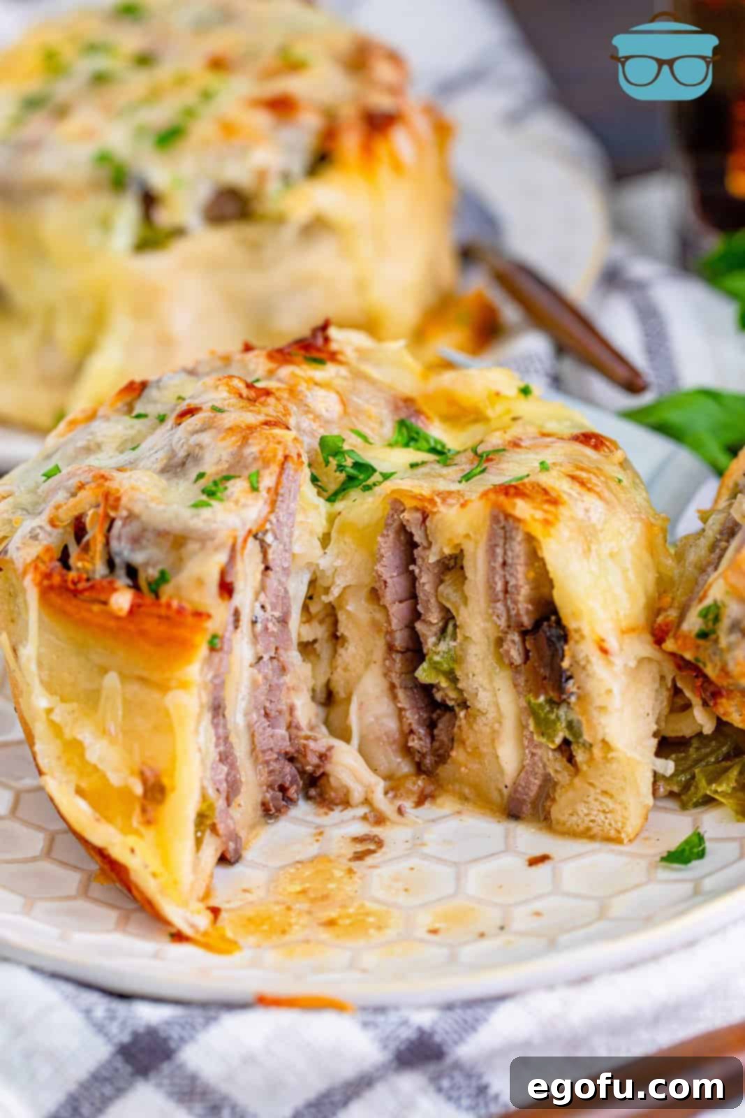 Philly Cheesesteak Pinwheels 2 Philly cheesesteak rollup on a plate with a bite removed.