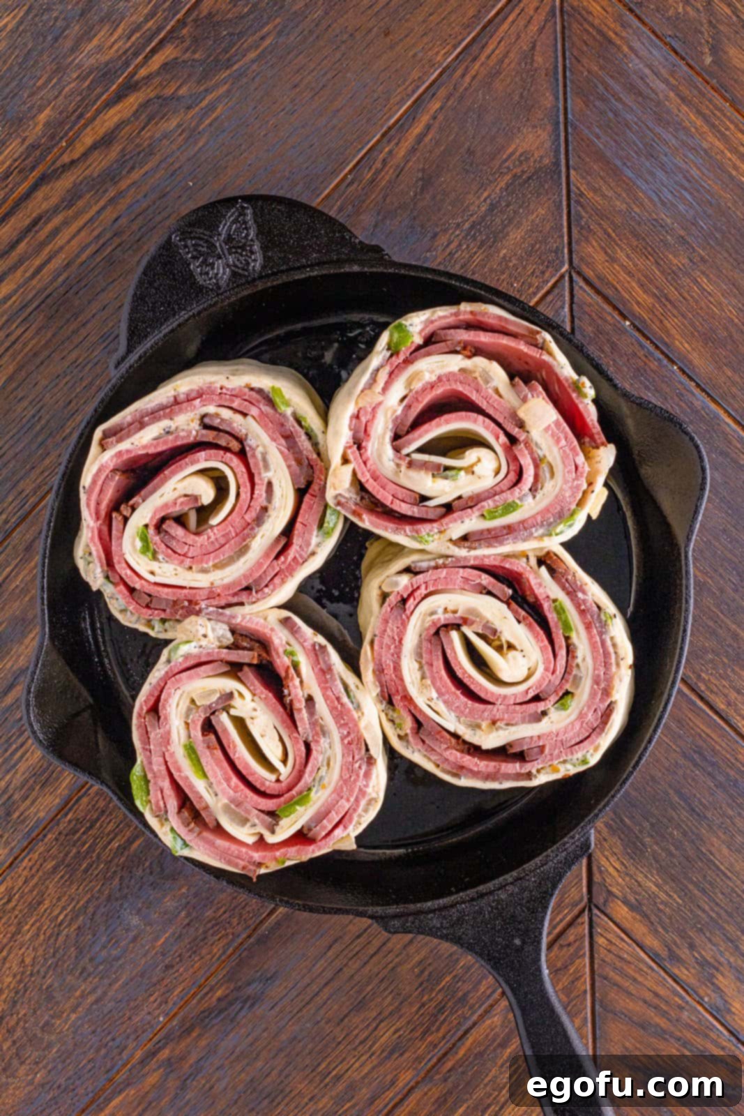 Philly Cheesesteak Pinwheels 14 four cheesesteak pinwheels in a cast iron skillet.