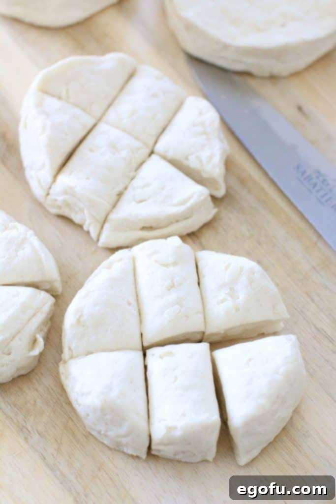 Canned biscuits being cut into 6 pieces for the French toast casserole.