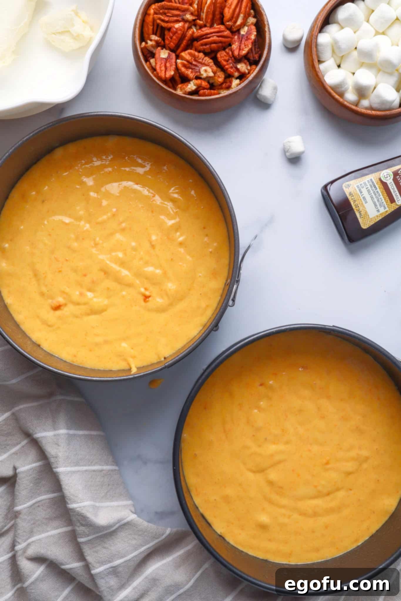 Effortless Sweet Potato Layer Cake 5 Sweet potato cake batter meticulously poured into two round springform pans, with the brown sugar swirl mixture dolloped on top, ready for gentle marbling.