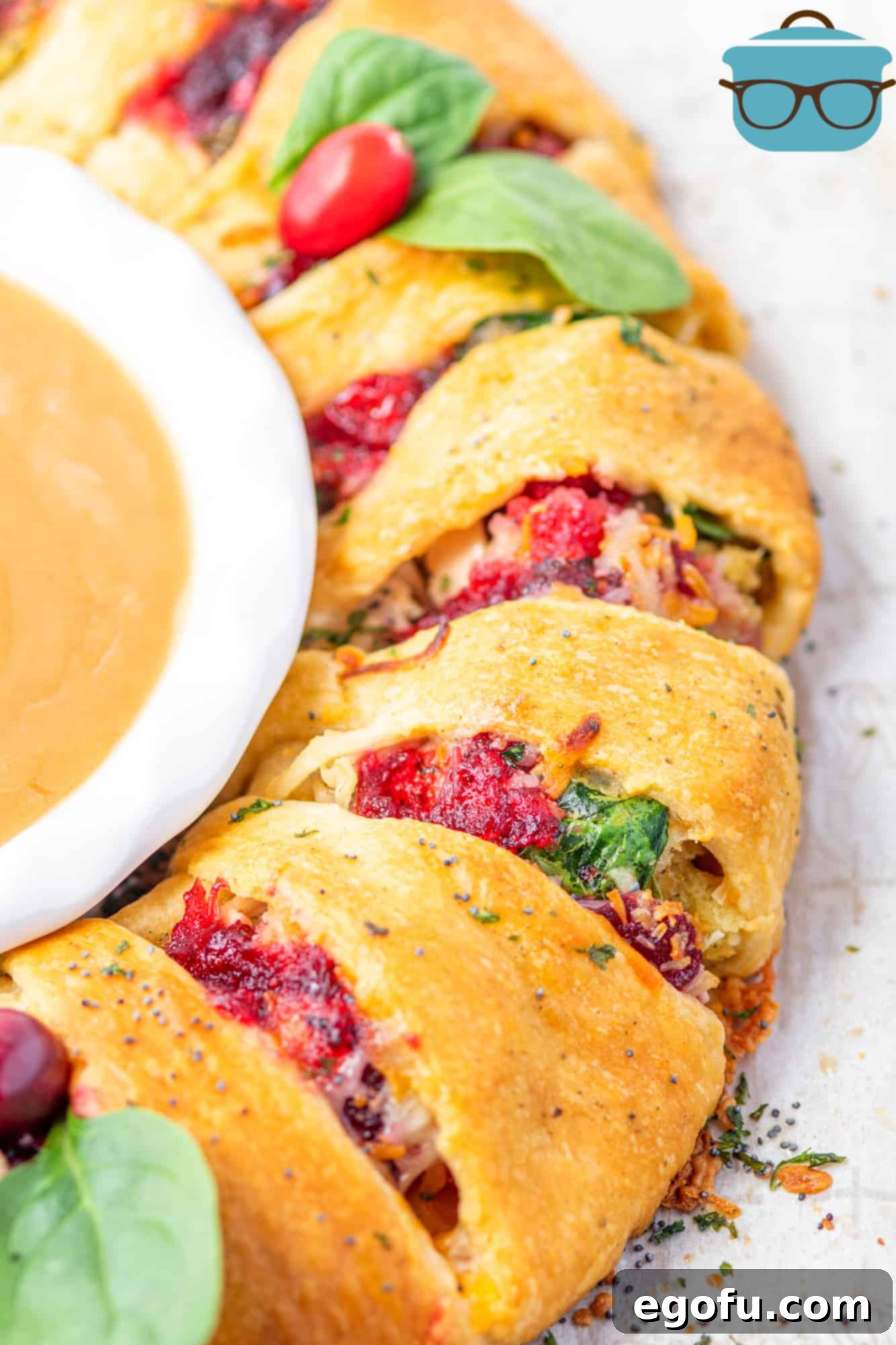 Festive Turkey Stuffing Crescent Bake 13 A close-up view of the fully baked turkey, stuffing, and cranberry sauce crescent ring, with a bowl of warm turkey gravy nestled in its center, glistening and ready to be enjoyed.