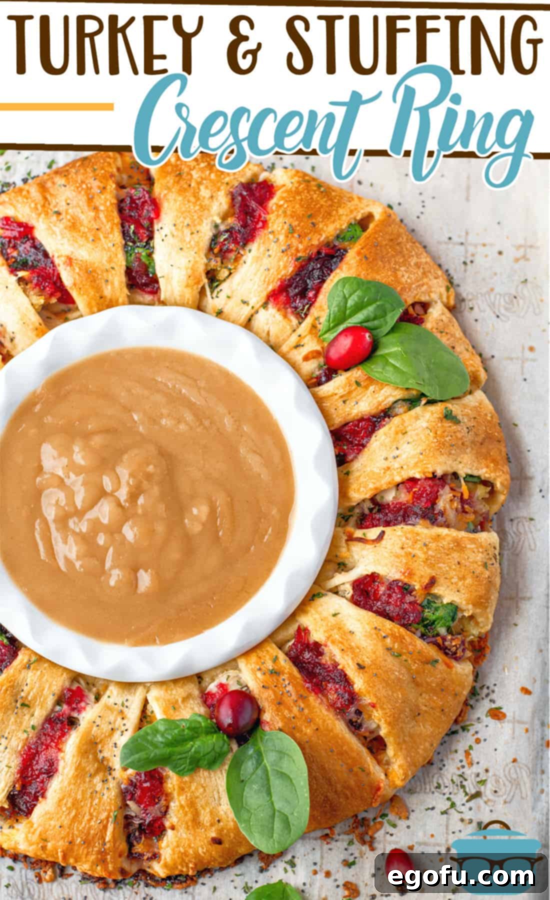 Festive Turkey Stuffing Crescent Bake 3 Leftover Turkey and Stuffing Crescent Ring recipe from The Country Cook, beautifully arranged on parchment paper, decorated with fresh spinach leaves and whole cranberries, showcasing its festive appeal before baking.