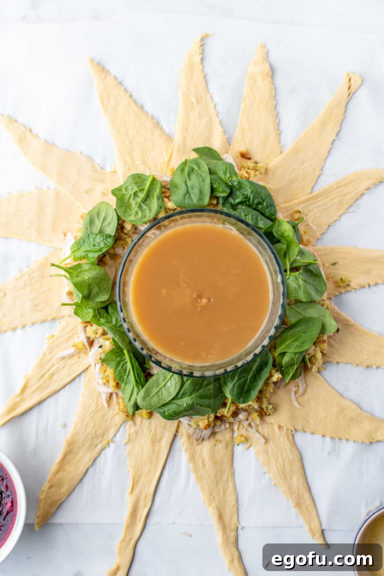 Festive Turkey Stuffing Crescent Bake 8 Fresh spinach leaves layered neatly on top of the turkey and stuffing mixture in the crescent ring.