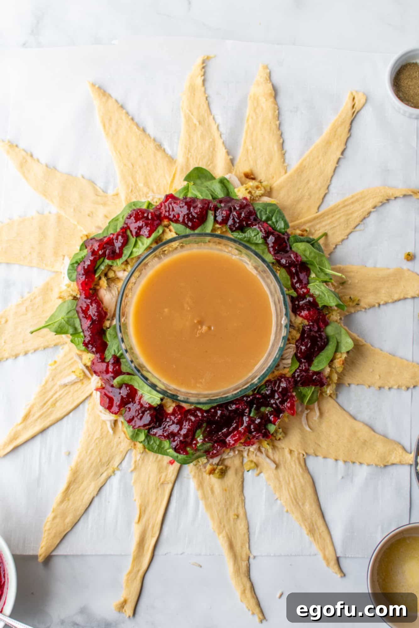 Festive Turkey Stuffing Crescent Bake 9 Cranberry sauce drizzled and spread evenly over the spinach leaves, adding a vibrant and tangy layer to the filling.