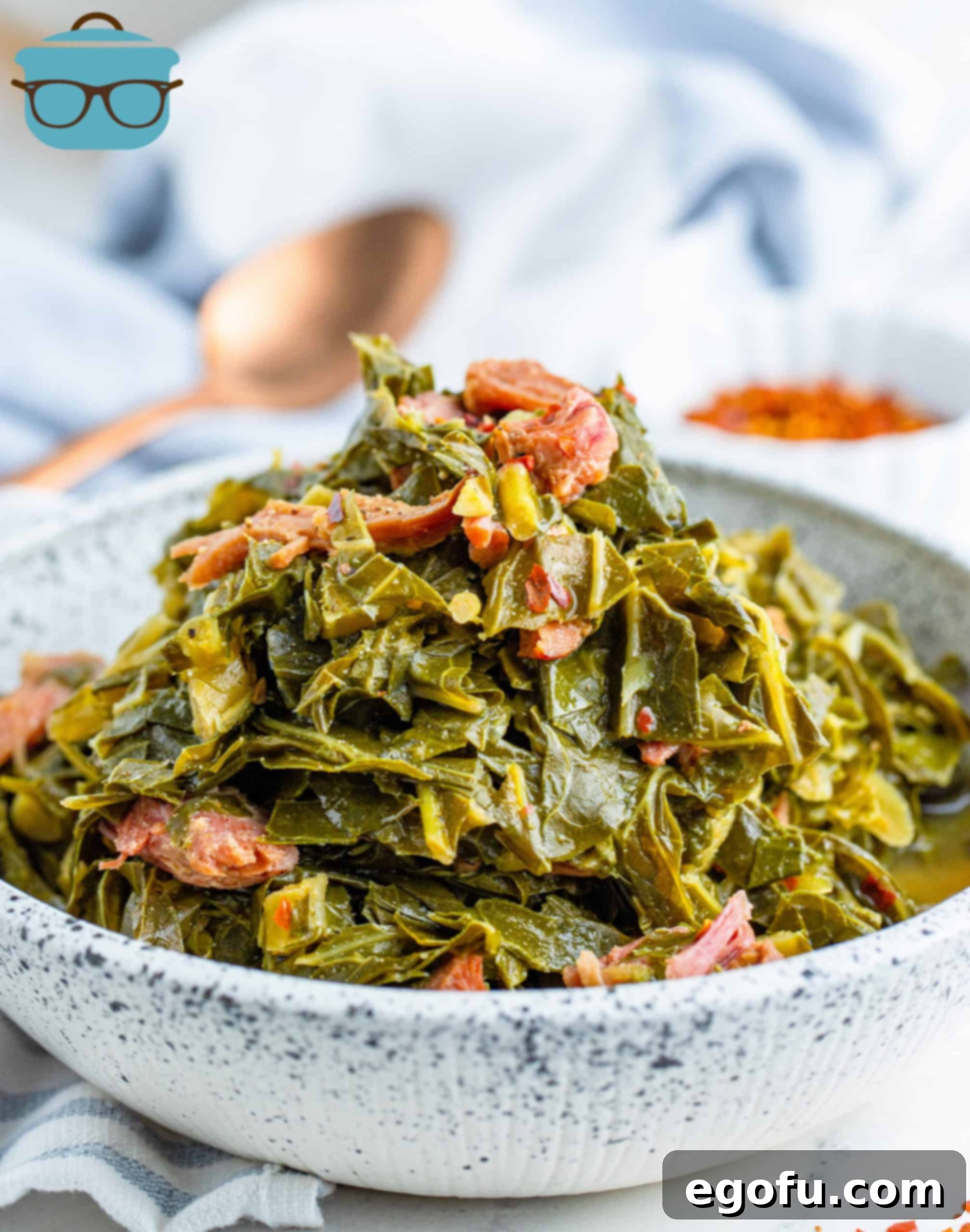 Cooked collard greens and ham in a bowl with a copper spoon, representing classic Southern comfort food.