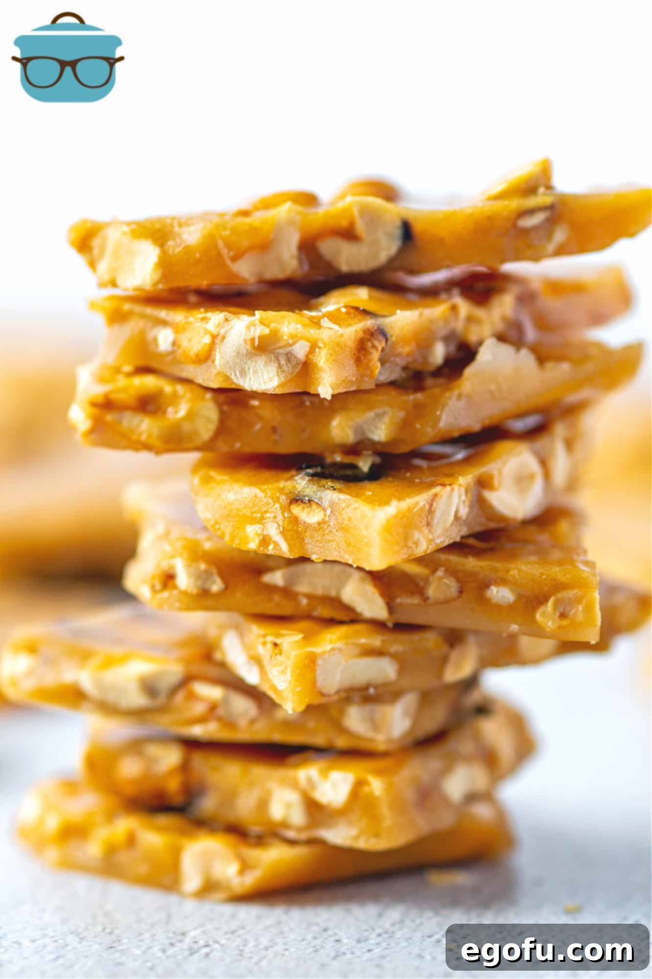 Golden Crunch Peanut Brittle 2 Homemade Peanut Brittle Candy pieces shown stacked in a pile, glistening and golden.