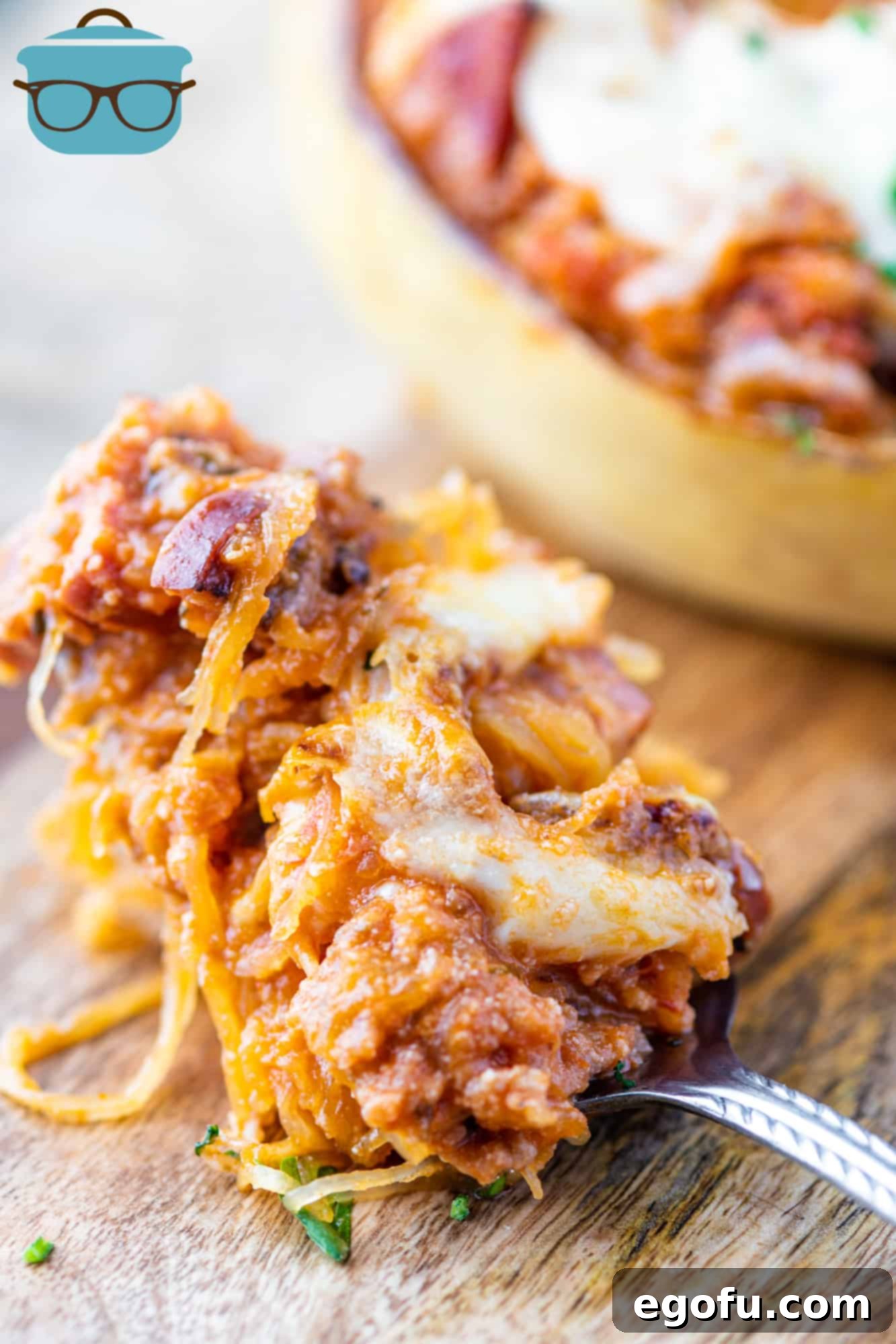 Italian Stuffed Spaghetti Squash, serving shown on a large spoon on a wooden cutting board, highlighting the cheesy, meaty filling and the spaghetti-like squash texture