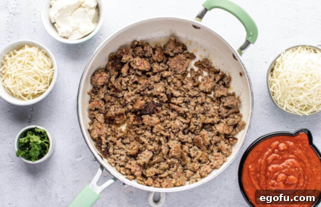 browning and crumbling ground Italian sausage in a skillet for the spaghetti squash filling, ensuring no pink remains
