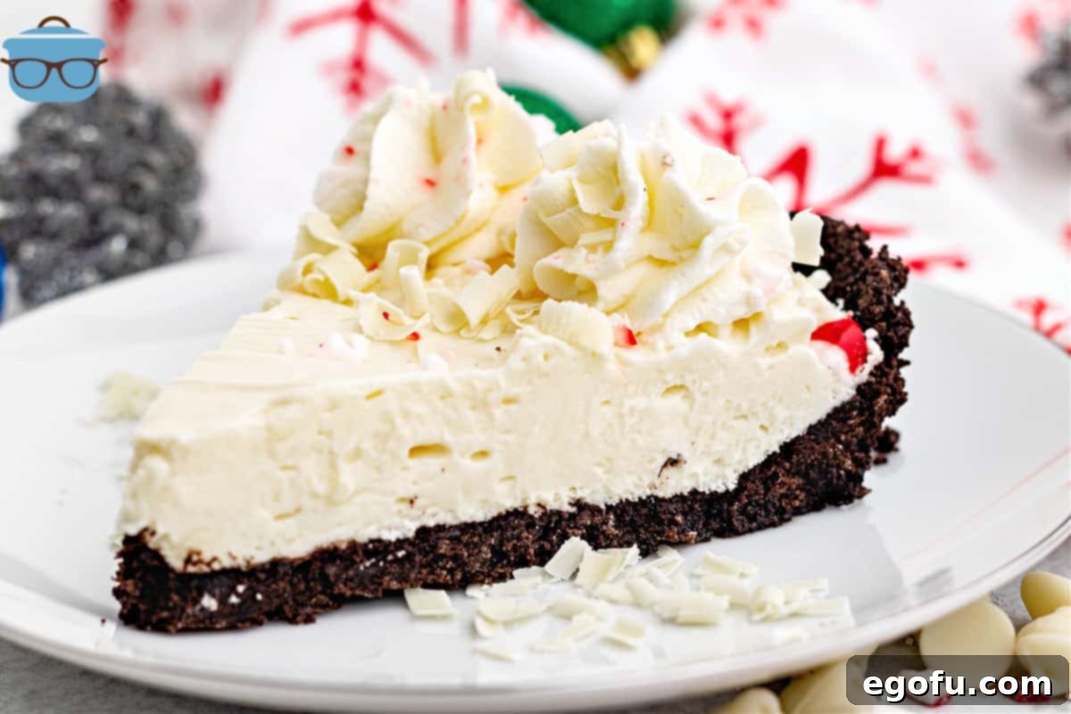 A perfectly cut slice of White Chocolate Peppermint Pie presented on a round white plate, ready to be enjoyed.