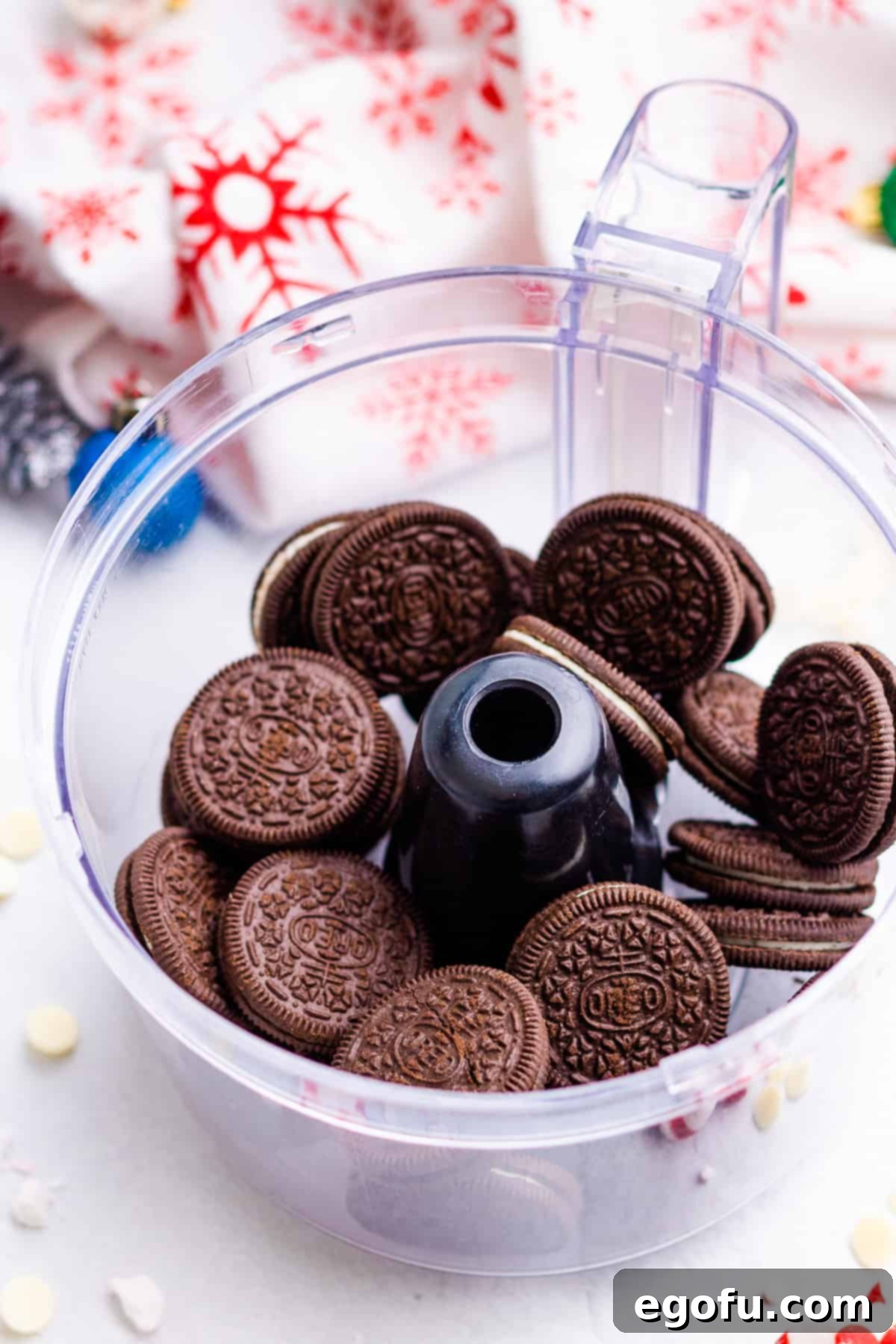 Oreo cookies resting at the bottom of a food processor bowl, ready to be crushed for the pie crust.