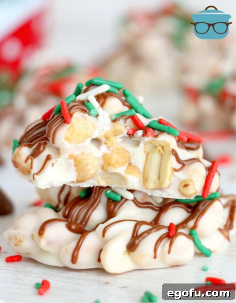 Two white chocolate peanut clusters stacked on top of each other, showcasing their delightful texture and appealing appearance.
