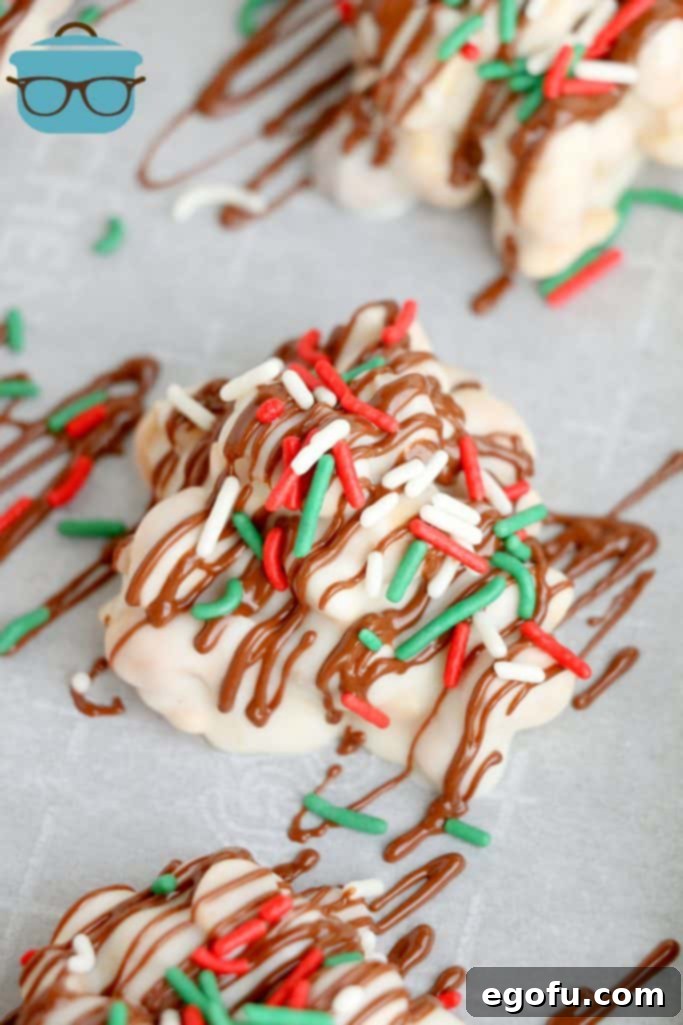 A close-up of a finished chocolate peanut cluster, generously adorned with festive red and green sprinkles, showcasing its holiday appeal.