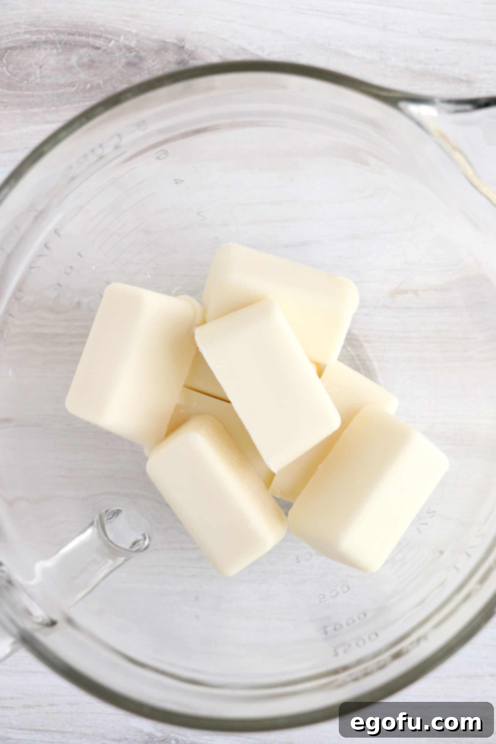 Vanilla almond bark in a clear glass microwave safe bowl, ready for melting.