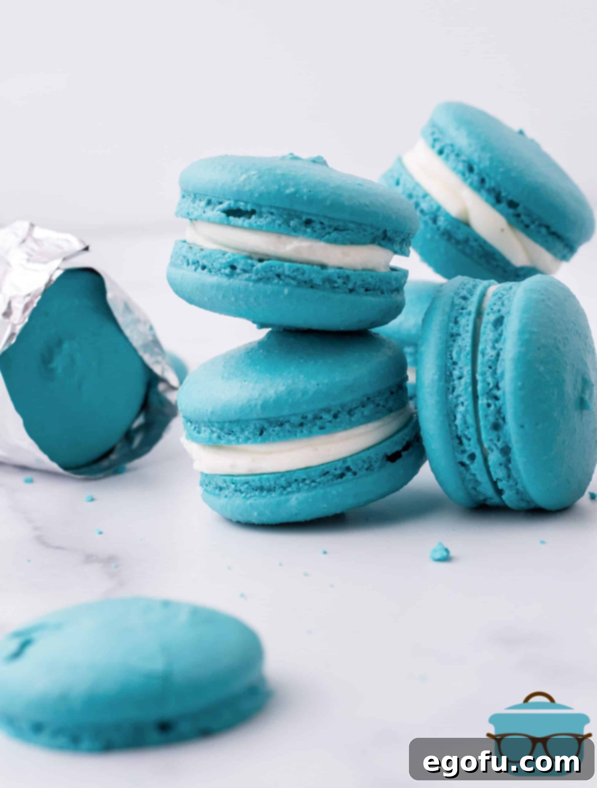 Teal blue macarons, a cosmic delight, stacked on a polished marble surface. These Space Macarons are a replica of the cookies eaten by Baby Yoda (Grogu) in The Mandalorian, bringing a piece of the Star Wars universe to your kitchen.