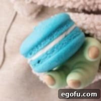 Baby Yoda (Grogu) holding a space macaron, a perfect representation of the Baby Yoda Cookie recipe.