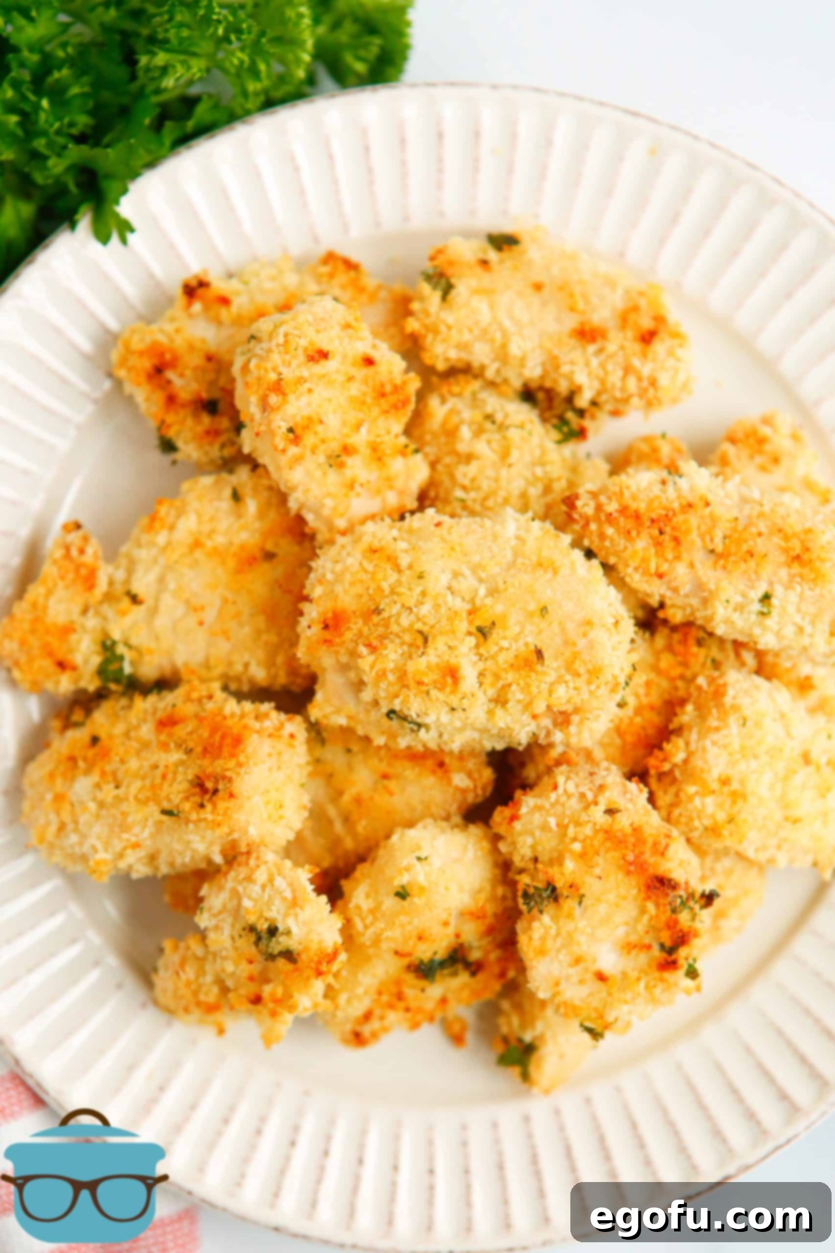 Stacked Easy Baked Ranch Chicken Nuggets on white plate, showcasing their golden crispiness.