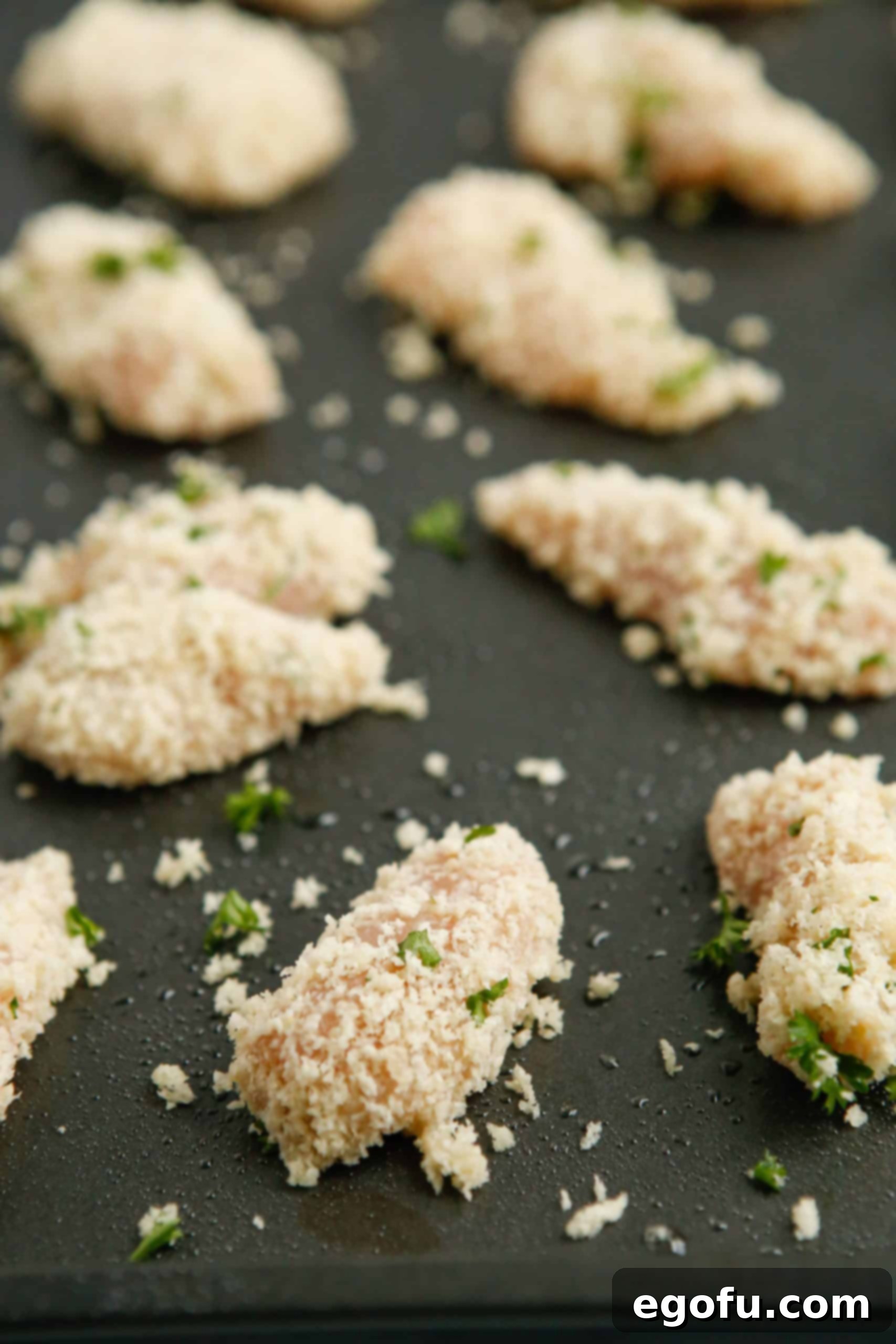 Chicken Nuggets on baking pan, perfectly arranged and ready for baking.