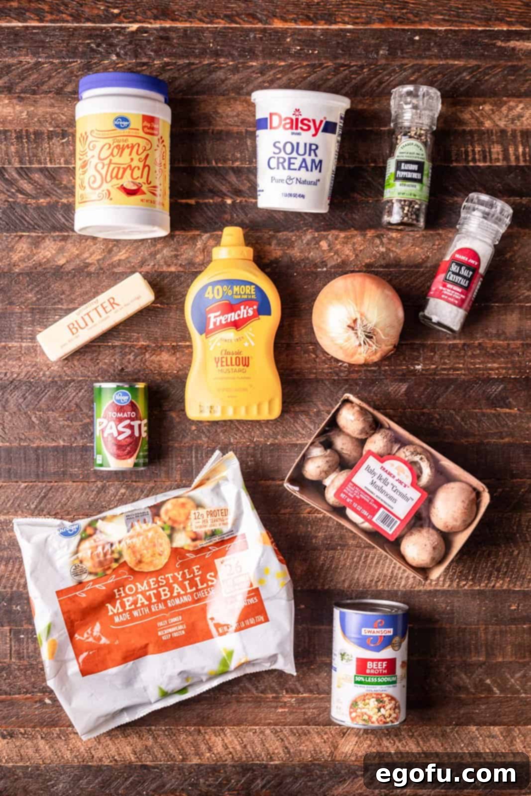 Ingredients laid out: frozen meatballs, beef broth, tomato paste, mustard, cornstarch, sour cream, sliced mushrooms, and diced onion.