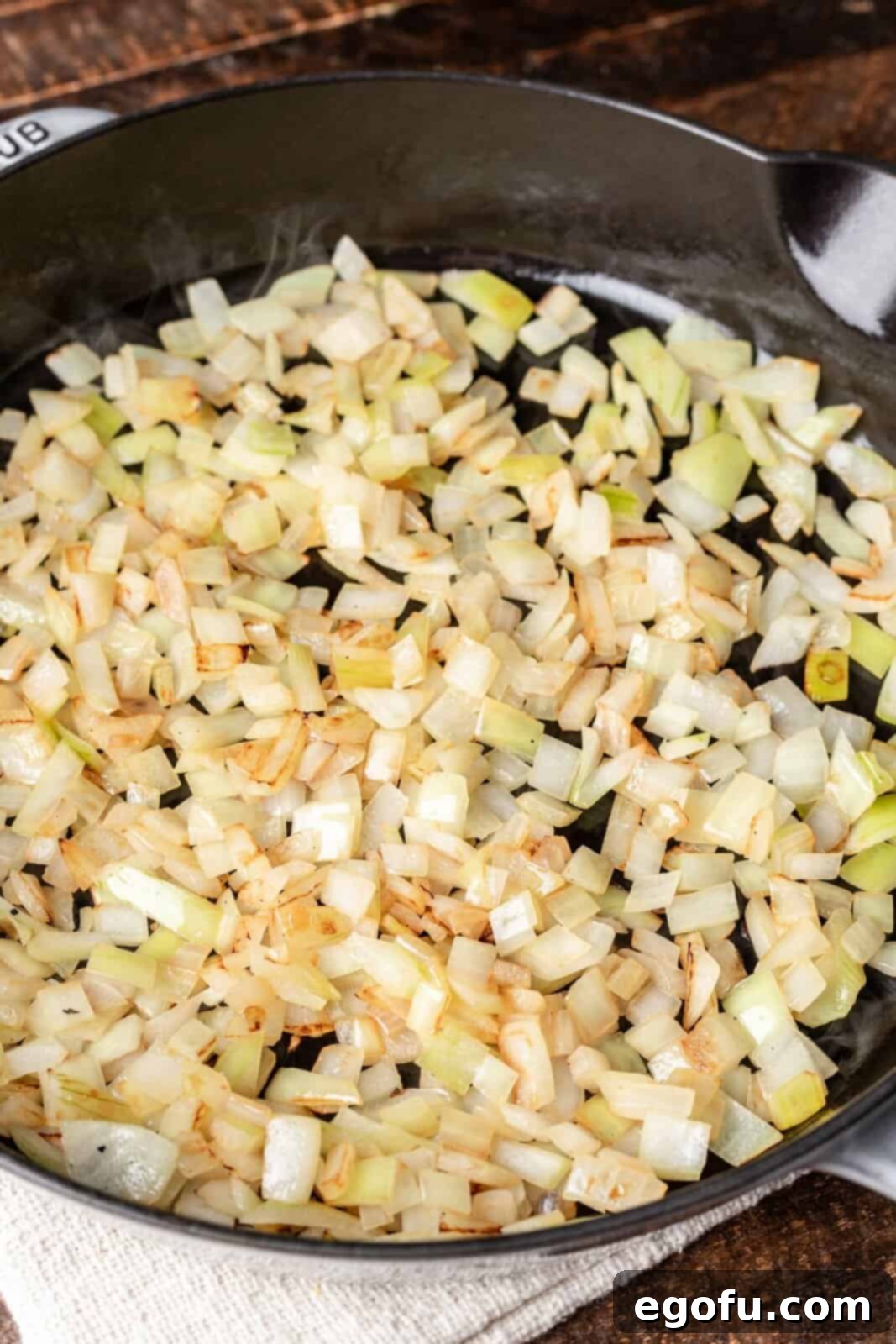 Butter melting and diced onions sautéing in a skillet.