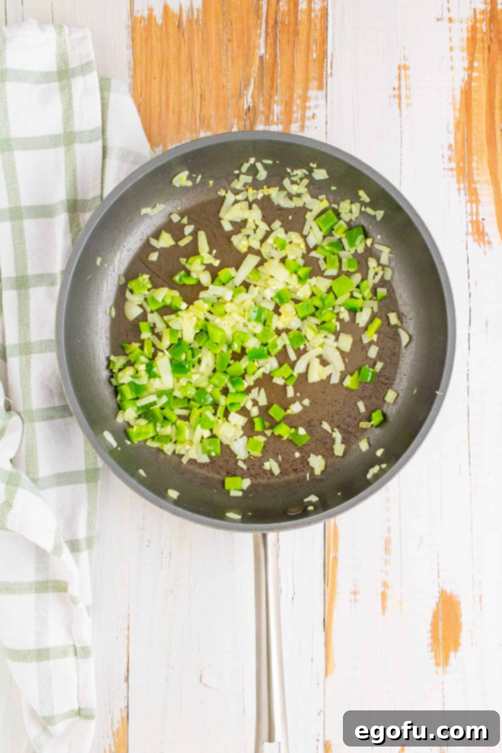 Philly Cheesesteak Poppers 5 Onions, garlic, and peppers sautéing in a skillet.