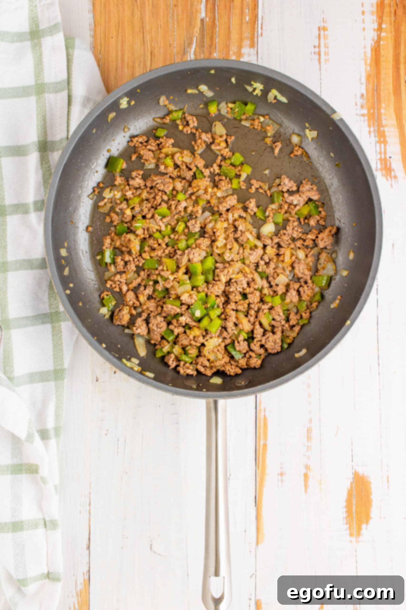 Philly Cheesesteak Poppers 6 Cooked and crumbled ground beef in pan with onions, garlic, and peppers.